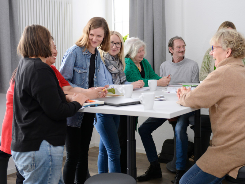 In einem Gespräch leitet eine Frau der Caritas anderen Personen an
