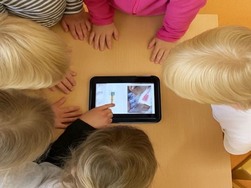 Kinderköpfe über Tablet gebeugt