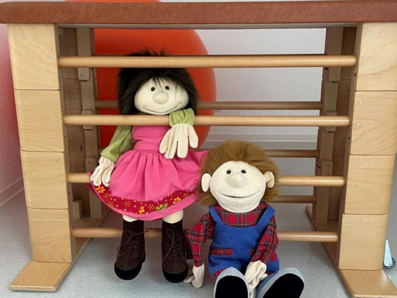 Therapieraum mit Puppen und Bewegungsgeräten für Kinder und Familien