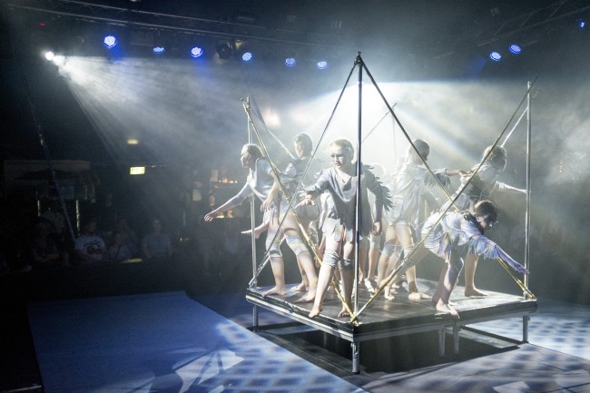 Mehrere Kinder stehen auf einer kleineren Bühne und geben eine Vorführung im Circus Schnick-Schnack