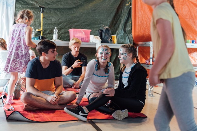 Kinderartisten sitzen in der Manege und haben Spaß