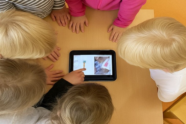 Kinderköpfe über Tablet gebeugt