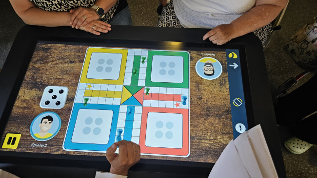 Mensch-ärgere-dich-nicht-Spiel auf dem digitalen Aktivitätstisch.