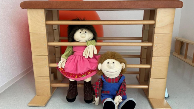 Therapieraum mit Puppen und Bewegungsgeräten für Kinder und Familien