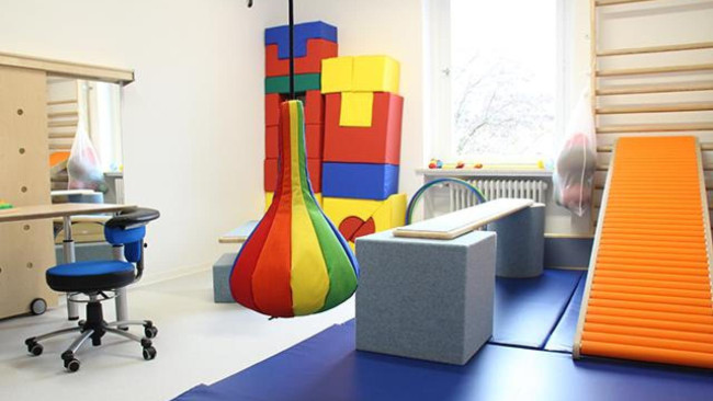 Bunter Bewegungsraum für Kindertherapie und spielerische Förderung