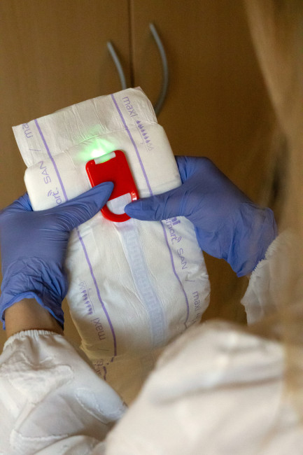 Pflegekraft befestigt einen Sensor an einem Inkontinenzprodukt
