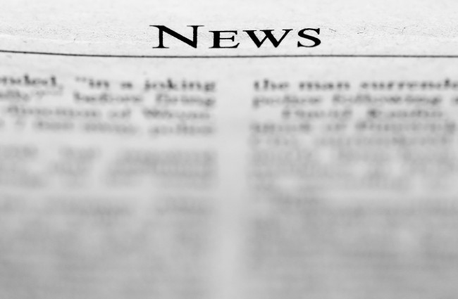 Symbolbild für Nachrichten und Presse: Nahaufnahme einer Zeitung mit dem Schriftzug „NEWS“ und unscharfem Fließtext.
